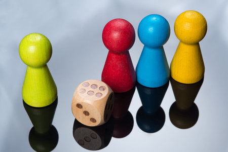 Colored pawns and dice, working together conceptual on black table