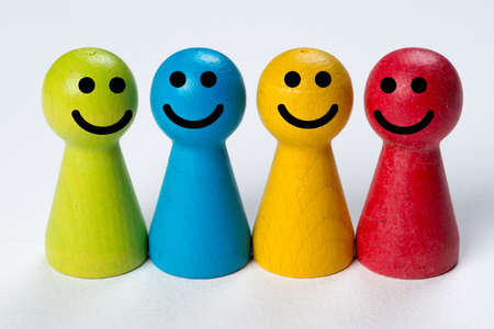 Colored happy pawns, working together conceptual on wood tableの写真素材