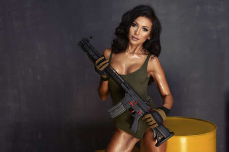 Young beautiful sexy brunette Woman holding Handgunの写真素材