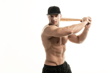 Close-up portrait of muscular man posing with a bat