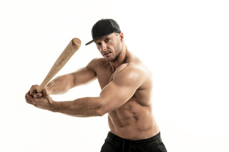 Close-up portrait of muscular man posing with a batの写真素材