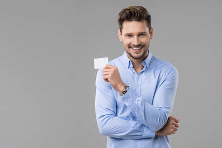 Handsome man in blue shirt  with white cardの写真素材