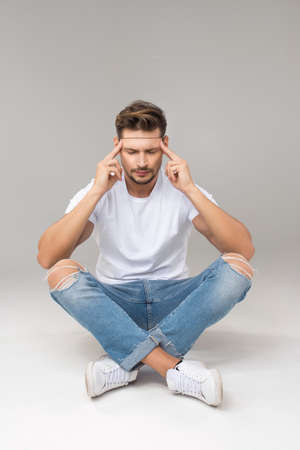 Thinking handsome man sittingの写真素材