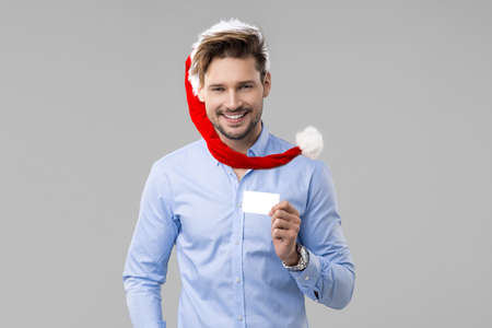 Handsome man wear Santa Claus hat in blue shirt with white cardの写真素材
