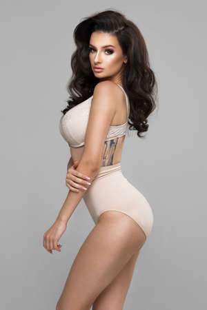 Sexy attractive brunette woman posing in fashionable lingerie in studioの写真素材