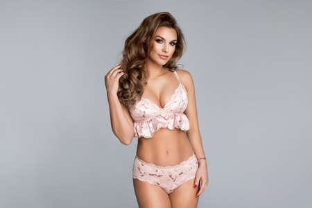 Sexy attractive blonde woman posing in fashionable lingerie in studioの写真素材