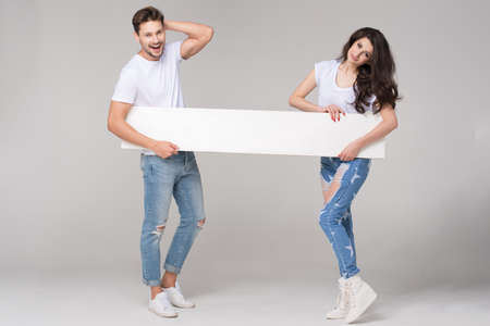 Happy summer couple with white boardの写真素材