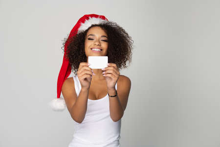 Happy afro woman wear Santa Claus hat with white cardの写真素材
