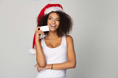 Happy afro woman wear Santa Claus hat with white cardの写真素材