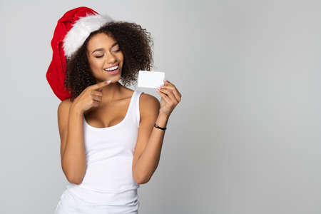 Happy afro woman wear Santa Claus hat with white cardの写真素材