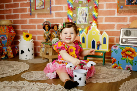 Cute little girl sitting on the floor in the room with toys
