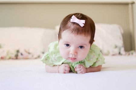 Portrait of a cute baby girl crawling on the bed at home