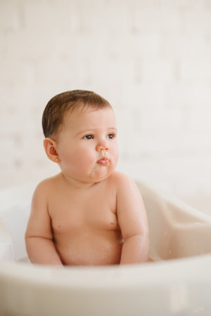 Portrait of a cute baby boy bathing in a bathtub.