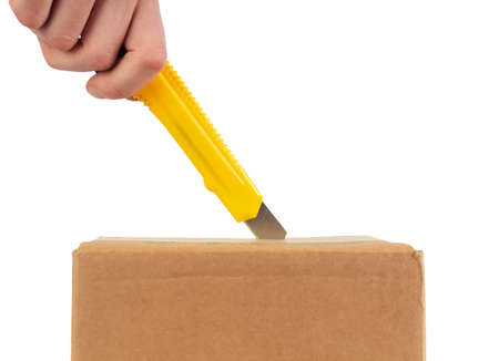 Close up of opening cartboard box with stationery knife.の写真素材