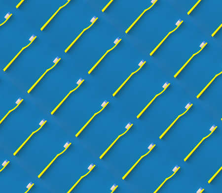 Yellow toothbrushes on blue background. Pattern. Health care concept.の写真素材
