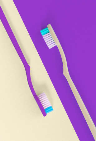 Two toothbrushes on soft cream and violet background. Top view.の写真素材