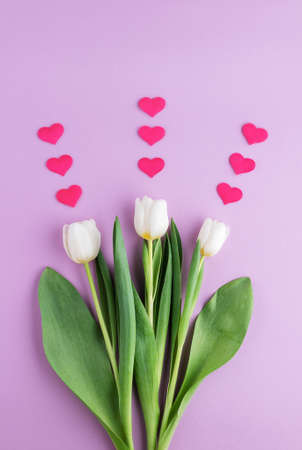 Set of three white tulips with hearts on pink background.の写真素材