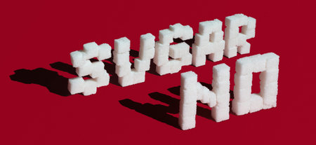 No sugar made with sugar cubes on red background. Concept of sugar addiction and diabetes.の写真素材