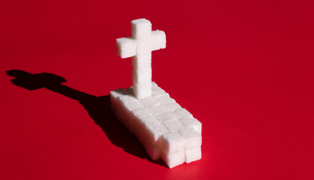 Sugar grave. Symbol of death under impact the use of sugar.の写真素材