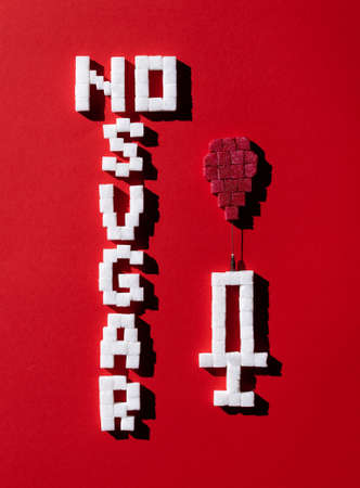 No sugar text and syringe with drop of blood on red background. Diabetes and sugar addiction concept.の写真素材