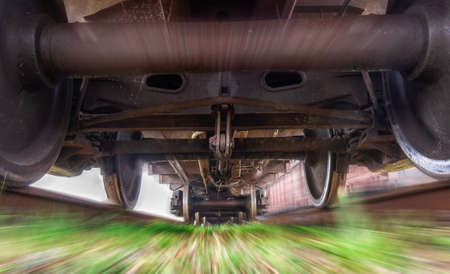 Freight train in motion. View under the train. Blurred background gives a feeling of movement.の写真素材