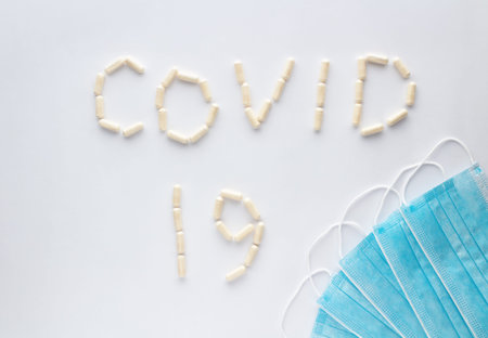 Covid-19. Medical protective face mask and pills on white background.の写真素材
