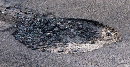 Big pit on the road. Concept of repairing pavement and replacing asphalt.の写真素材