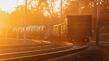 Industrial landscape of a freight train on a railroad at sunset. Transportation of heavy loads. Cargo transportation.の写真素材