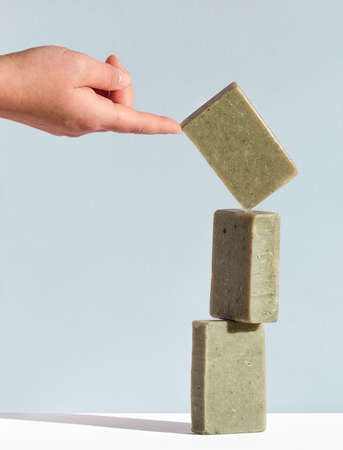 Womans hand holding a falling bar of natural soap. Handmade cosmetics concept.の写真素材