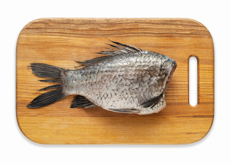 Peeled and chopped carp on a kitchen wood boardの写真素材
