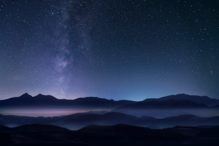 Starry night sky with milky way over the mountains.の写真素材