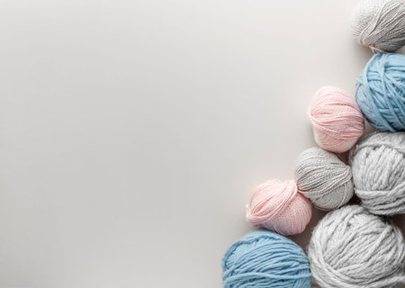 Balls of yarn on soft beige background with copy space.