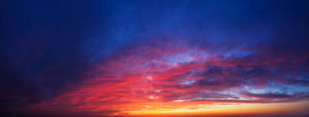 Dramatic sunset sky background. Panorama of twilight sky with clouds.の写真素材