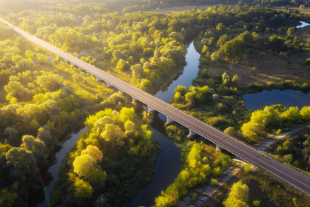 Road bridge across the river at dawn on a summer morning. Beautiful landscape from aerial drone...