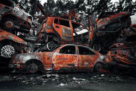 Shelled and destroyed rusty civilian cars. Consequences of the military invasion of the Russian army in Ukraine. Irpin, Kyiv region, 2022.の写真素材