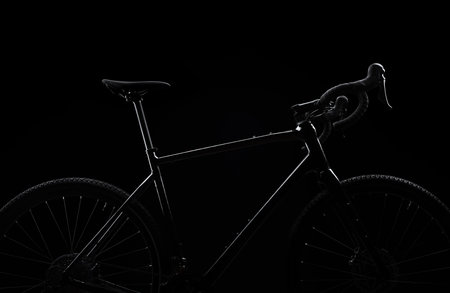 Silhouette of black gravel bike on black background. Studio shot. Professional sports equipment.