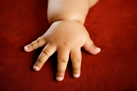 Children s hand isolated on red backgroundの写真素材