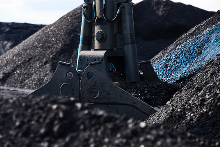 Coal loading excavator, heaps of coal