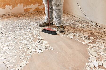 Builder sweeping the floor after renovationの写真素材