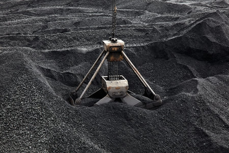 Coal loading excavator, heaps of coal