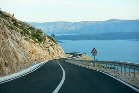 A new, winding and empty road on the seashore. Island of Brac, Croatia. New, recently built asphalt road.の写真素材