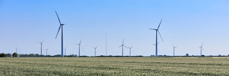 Wind turbine among green ears of grain crops. Windmill turbine is an environmentally friendly source...