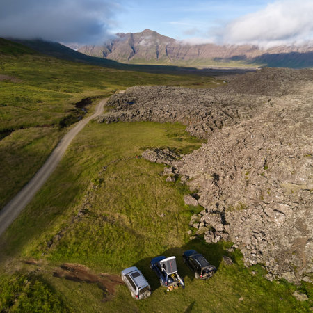 Three off-road cars at a campsite next to a lava field. Top view, photo taken from the drone. Helgafellssveit, Icelandの写真素材