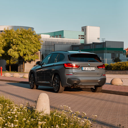 BMW X1 25e, hybrid, plug in car, parked next to a modern office building. The total power of both engines is 220HP. Electric range up to 52 km Katowice, Poland- 07.30.2021のeditorial素材