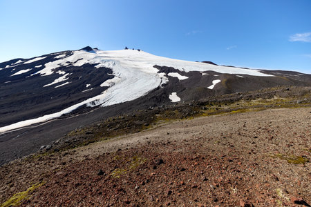 Majestic SnÃ¦fellsjÃ¶kull rises in Iceland, featuring a blend of rocky terrain and glistening glaciers while basking in bright sunlight on a clear day. A perfect day for explorationの写真素材