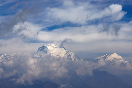 Trekking along the Annapurna trail in Nepal reveals stunning mountain views and vibrant prayer flags. The clear sky enhances the breathtaking scenery of the Himalayasの写真素材
