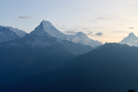 Stunning snow-covered peaks rise majestically against the morning sky at Poon Hill, offering breathtaking views of the South Annapurna region in Nepal.の写真素材