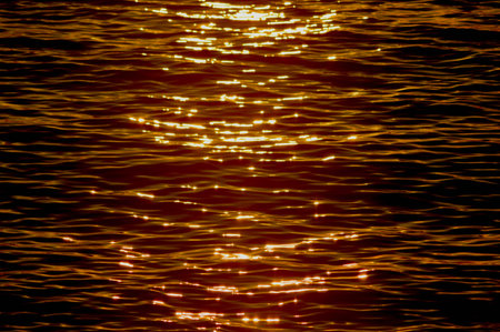 Small sea waves in orange and black colors, natural lighting