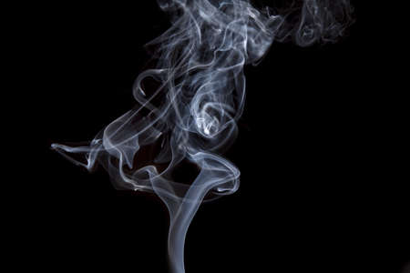 Smoke volutes on a pure black background の写真素材