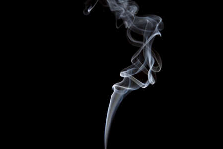 Smoke volutes on a pure black background の写真素材